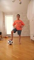 A boy in an orange shirt standing on a wooden floor video
