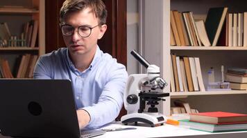 A man in glasses is using a laptop computer video
