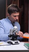 A man looking at a microscope video