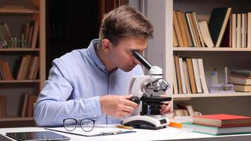 A man looking through a microscope at a book video