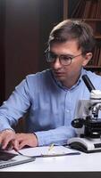 A man in glasses is looking at a laptop computer video