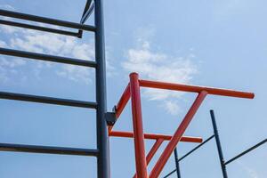 Parallel bars stand in a gym environment under a bright blue sky, inviting users to engage in fitness routines and active training sessions photo