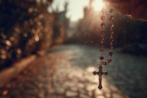A rosary hanging from a person's hand photo