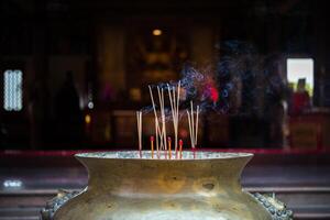 A large vase with incense sticks in it photo