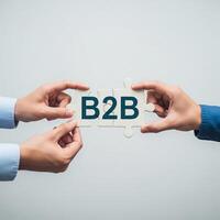 Two hands connect puzzle pieces with the letters b2b symbolizing business partnership photo