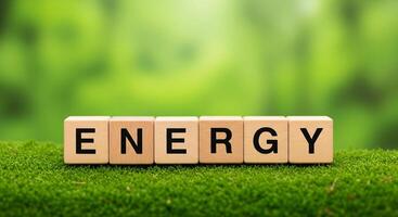 Wooden blocks spell out energy on lush green moss background photo