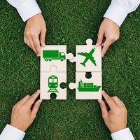 Hands assembling a logistics puzzle with truck train airplane and ship icons on grass photo