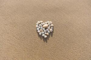 Sandy Background with Heart Made of Shells photo