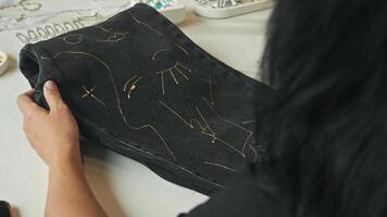 In workshop for creating craft jeans from old denim, skilled craftsmen work manually and decorate garments with variety of embellishments. video