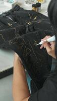 creating unique craft jeans. the designer customizes jeans using paint by painting on them. High angle. video