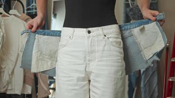 A girl tries on a skirt at a craft denim clothing store, which has a unique design and decoration. video