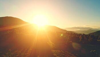 Brilliant Golden Sunrise Erupting Over a Serene, Forested Mountain Range photo