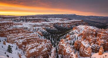 The sun sets over the snow covered mountains in bryce canyon photo