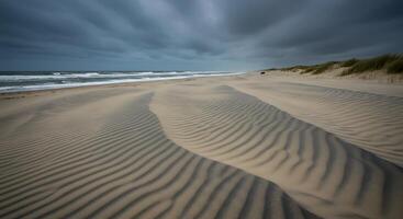 Sand dunes on a beach with storm clouds in the background photo