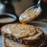 Creamy Nut Spread Drizzled onto Toasted Bread. A Close-Up Food Photography Image. photo