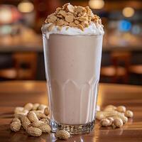 Creamy Peanut Butter Milkshake in a Glass, Garnished with Peanuts. photo