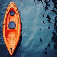 Aerial View of a Bright Orange Kayak on Serene Blue Water. This image is perfect for travel, adventure, or summer themes. photo
