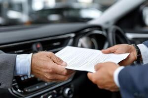 Two men shaking hands in a car dealership photo