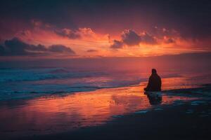 A person sitting on the beach at sunset photo