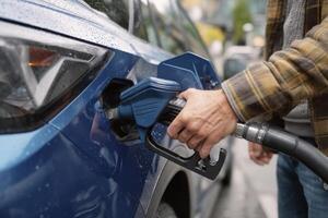 A man is filling his car with gas photo
