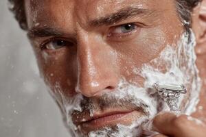 A man shaving his face with a razor photo