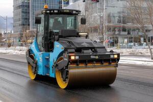 A blue and yellow roller on a city street photo