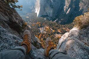 A person wearing yellow shoes on top of a mountain photo
