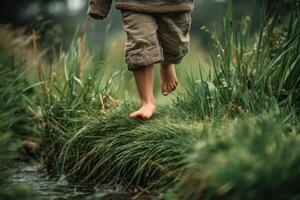 A child's bare feet are walking across a stream photo