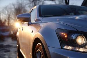 A car is parked on a street at sunset photo