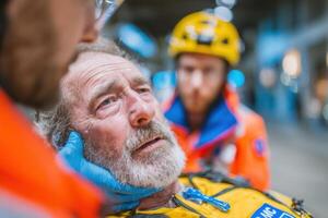 A man in a yellow vest is being examined by two men photo