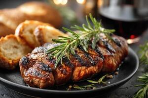 Grilled steak with rosemary and bread on a black plate photo