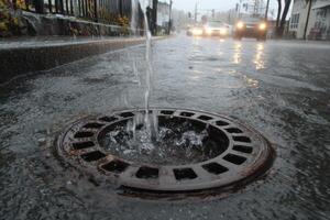 A water drain is open on the street photo