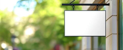 The Blank Sign Hanging Outside a Modern Storefront in a Vibrant Urban Environment photo