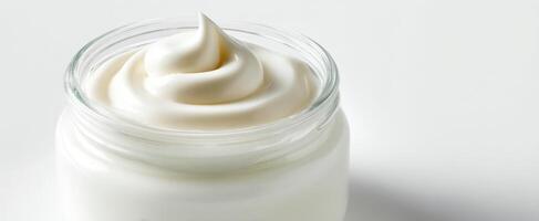 The luxurious cream in a glass jar showcasing smooth and rich texture. photo
