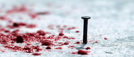 The nail surrounded by vivid red splashes, evoking intense emotions and danger. photo