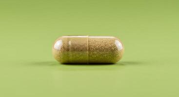 A pill on a green surface with a close up of the pill photo