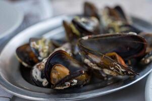 A delectable dish of fresh mussels served with a slice of lemon.. photo