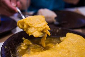 Portion of Betanzos omelette with juicy egg to serve with a lid in a restaurant photo