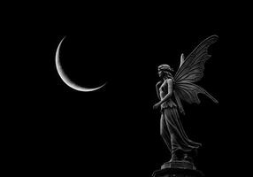 Fairy statue with butterfly wings and moon photo