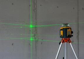 A laser level on a tripod with green lights photo