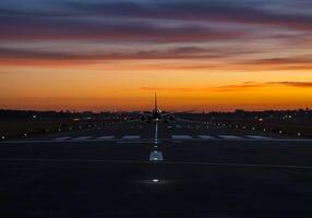 A plane on the runway at sunset photo
