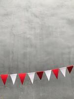 Red and white triangular bunting flags hang against a gray background, creating a festive and cheerful atmosphere., perfect for Indonesia independence day concept, photo