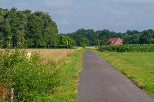 A paved road with a house on the other side photo