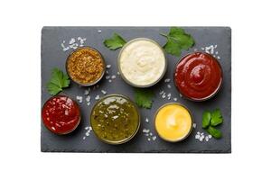 Many different sauces and herbs isolated on white background, flat lay top view. sauces on plate, photo