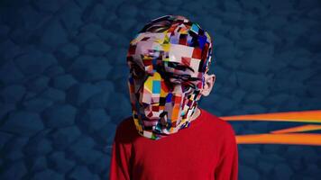 Person with colorful geometric mask standing against an orange and blue striped background, creating a surreal and artistic portrait exploring themes of identity, disguise, and modern art video
