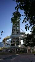 Industrial chimney of former GALP refinery with spiral walkway surrounded by buildings in Parque das Nacoes Lisbon video