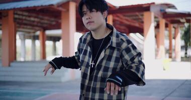 Handheld selective focus shot, Young Asian man with dancing skills is practicing new moves by himself. Enjoy the rhythm and creativity. Solo dance. video