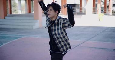 Handheld high angle view shot, Young man with dancing skills is practicing new moves by himself. Holiday activity. video