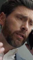 Close up Caucasian businessman worried anxiety business man in office portrait talking mobile phone discuss bad news failure problem communicate male entrepreneur stressed talk call looking in window video