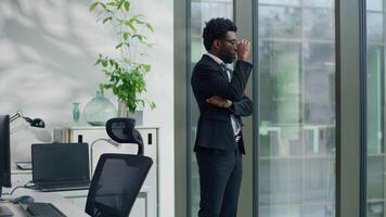 Pensive African American business man stressed worried anxiety thinking in office looking to window gazing create solution bad trouble think ethnic businessman male work difficult pondering overworked video